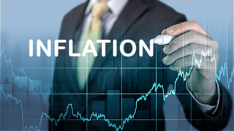 Person writing the word inflation