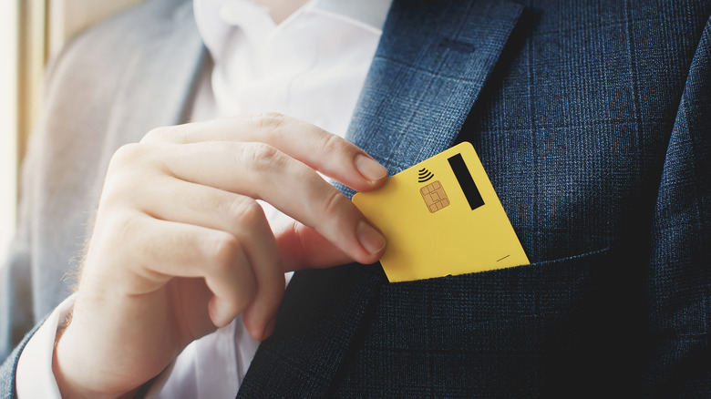 Man putting gold card in pocket.