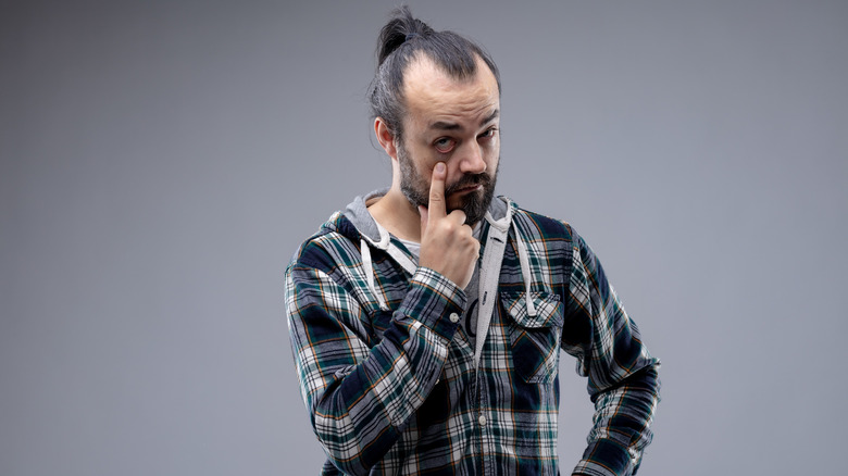 Man demonstrating the eyelid pull gesture