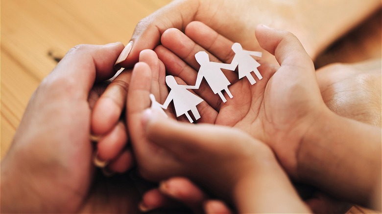 Nesting hands, holding family cutout