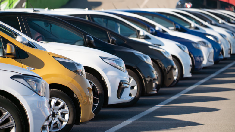 A line of white, black, gold, and blue cars