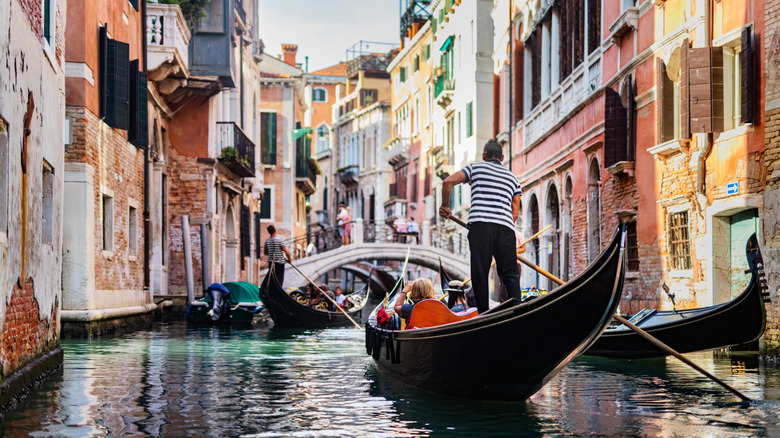 Gondoliers piloting through the canals of Venice
