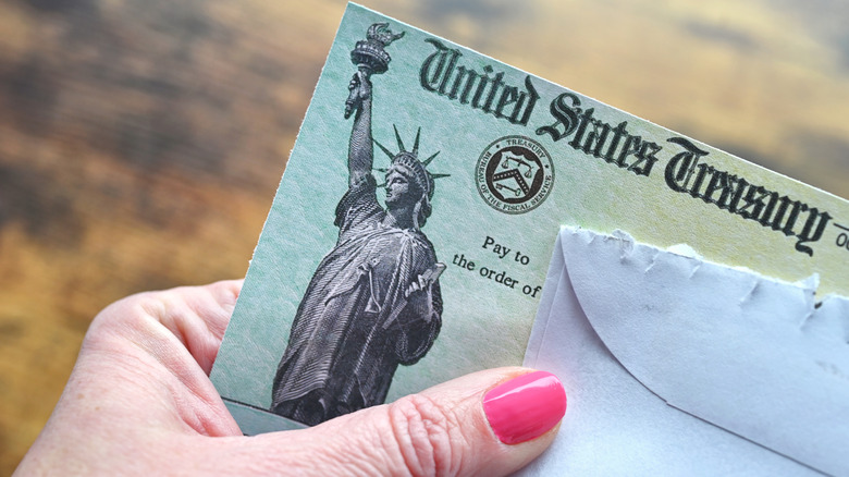 Women holding monthly Social Security benefits check.