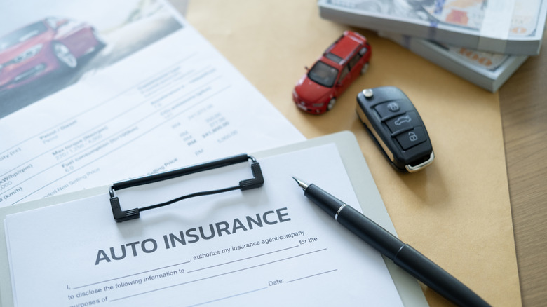 An auto insurance document on a disk with a toy car and a car key
