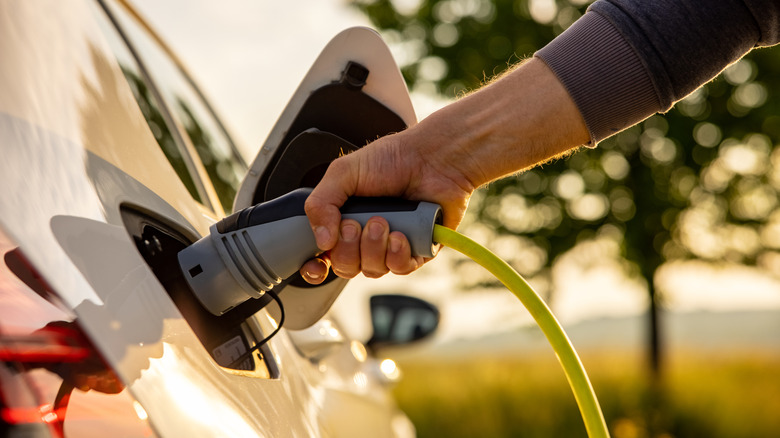 Person refueling electric vehicle