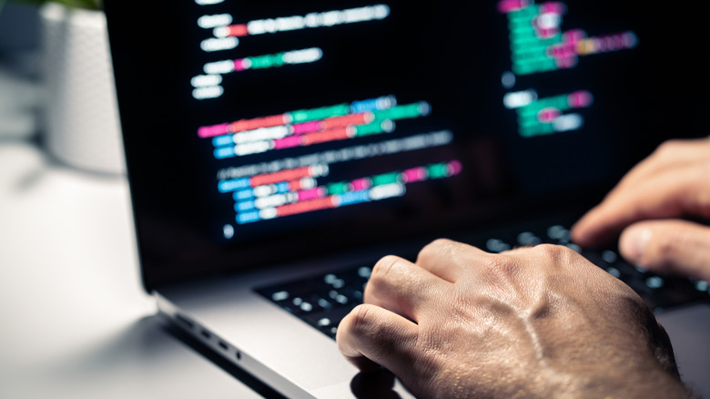 Hands typing on a laptop