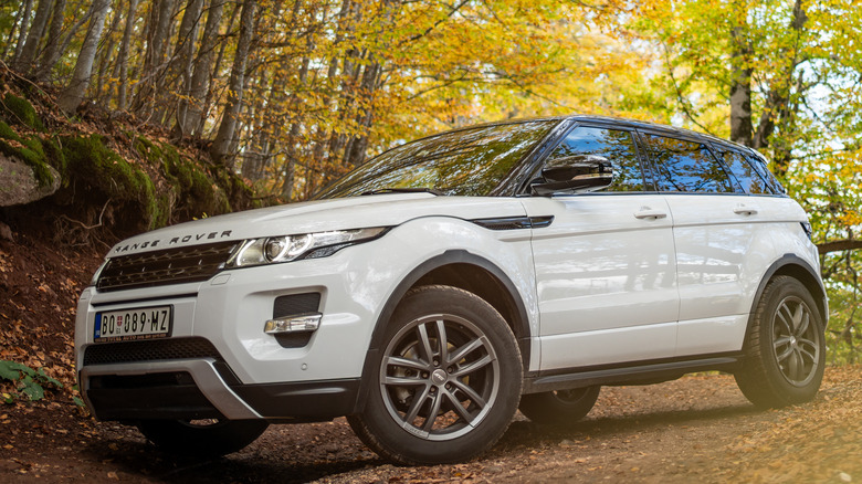 Close up of Land Rover SUV driving in woods