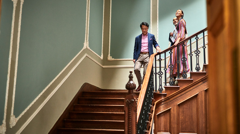 people walking down a luxurious home staircase