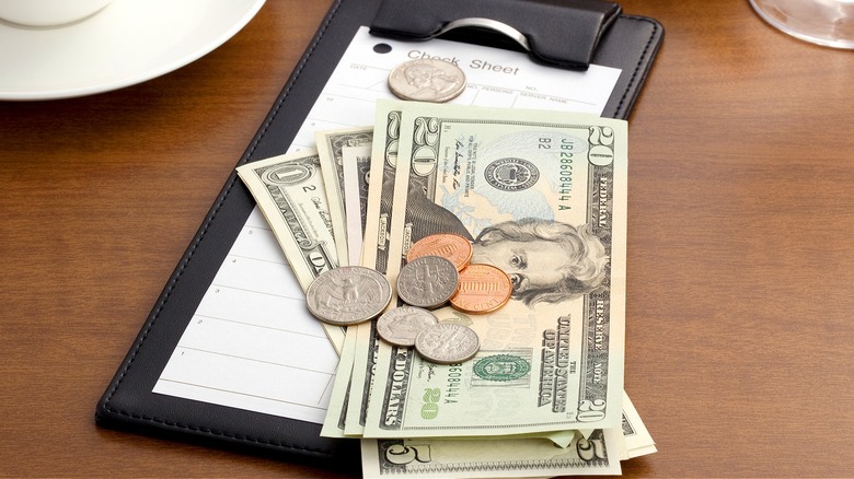 Paying restaurant check with cash
