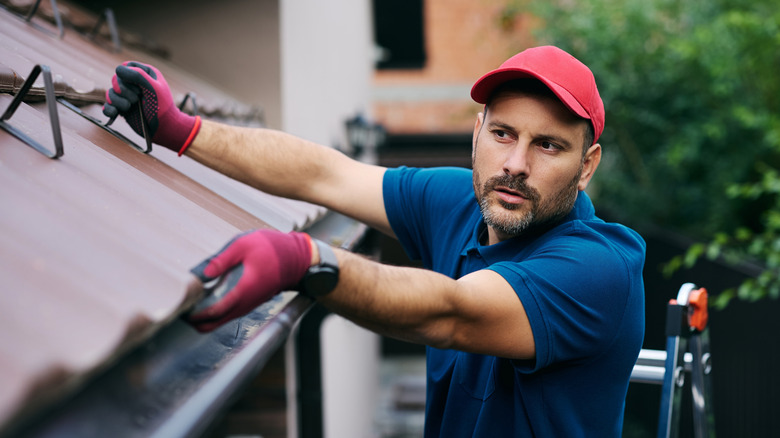 Construction worker fixing roof.