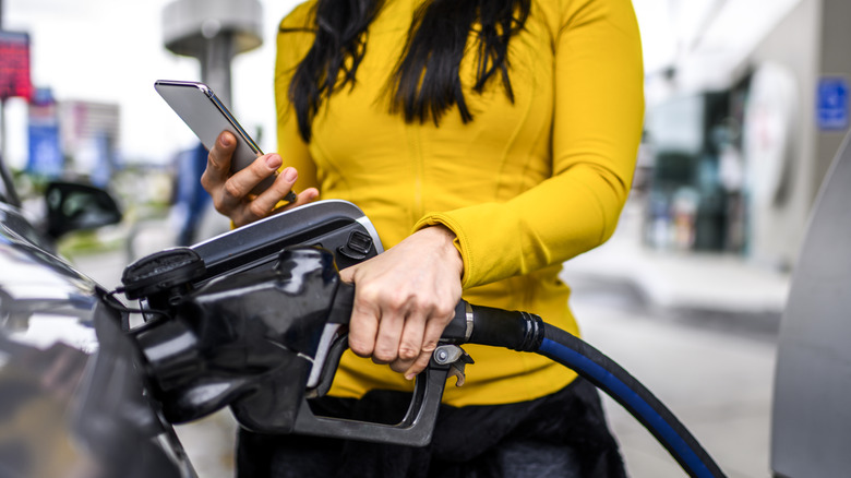 A woman filling up gas tank