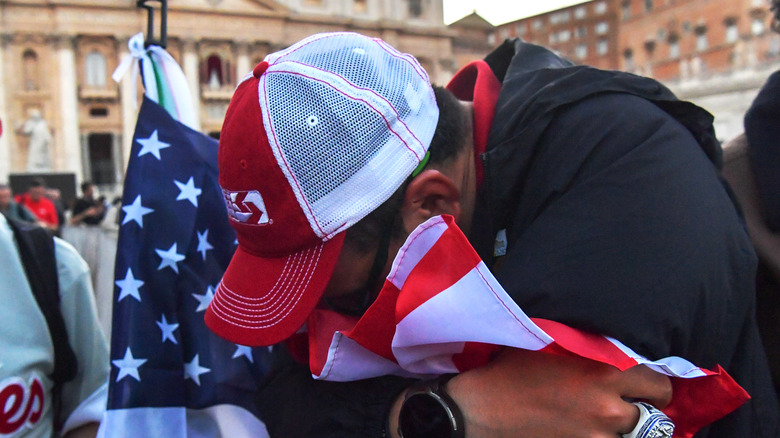 American man cries and kisses the flag of the United States of America in St. Peter's Square after the election of Pope Leo XIV on May 8, 2025