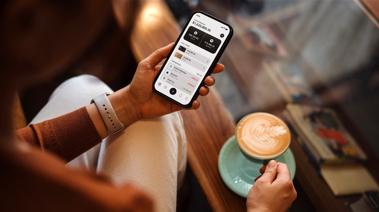 Person with coffee reviewing financials