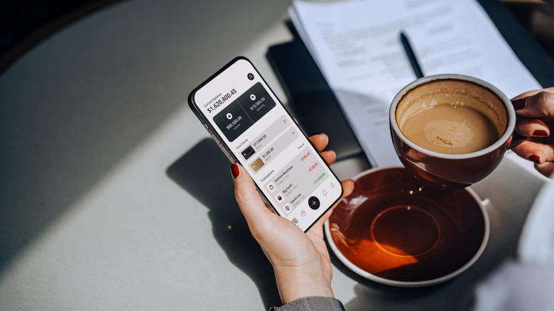 wealthy person looking at account info and drinking coffee