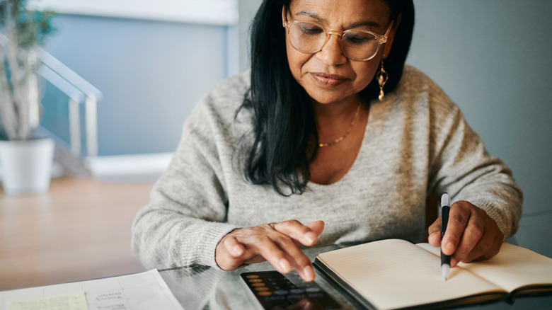 older Black woman using a calculator
