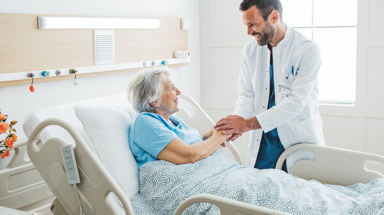 Doctor talking to senior woman in hospital bed