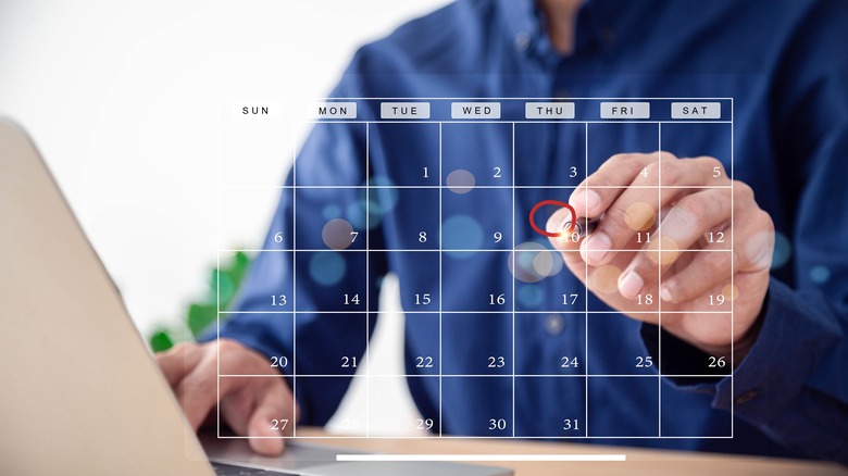 Man marking a date on a digital calendar