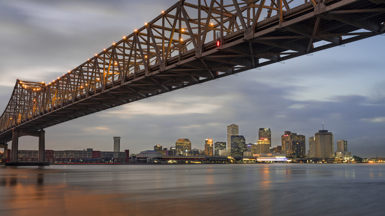 Bridge over river with New Orleans skyline in background