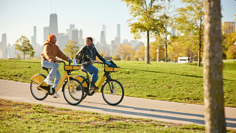 Pair of women riding through park on their bikes