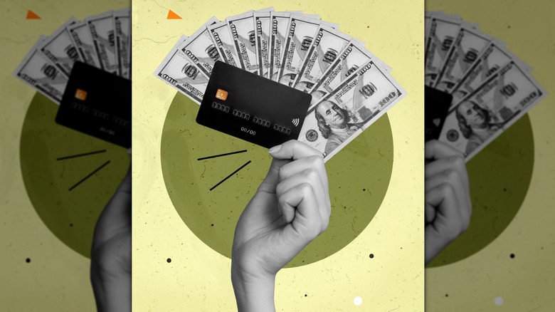 Hand holds credit card and dollar bills