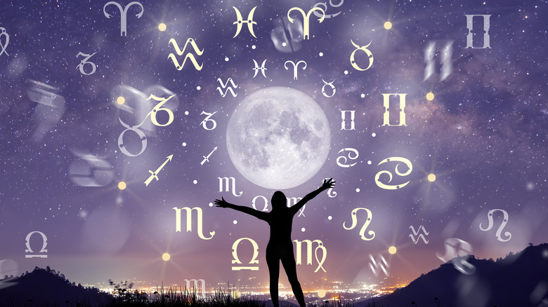 Silhouette gestures towards moon and zodiac signs