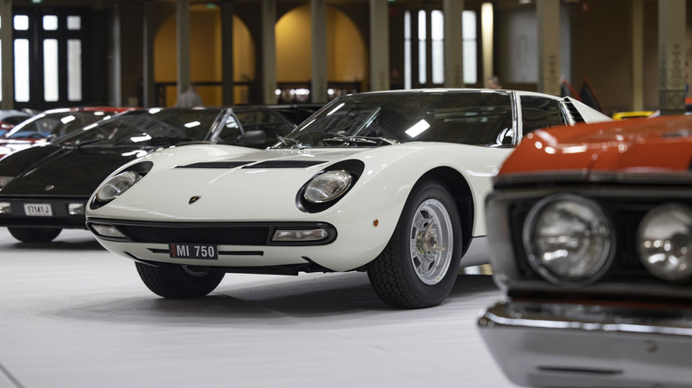 a line of classic '70s cars in a showroom