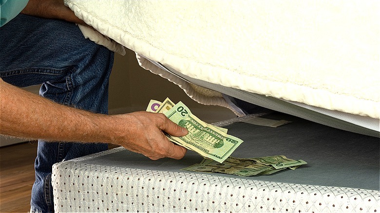 Person placing savings under mattress