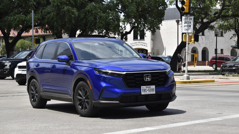 A blue Honda CR-V driving through an intersection