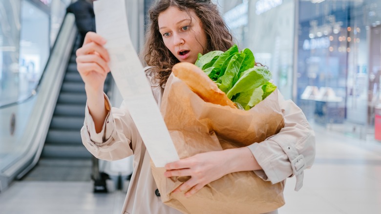 Person reviewing long grocery receipt
