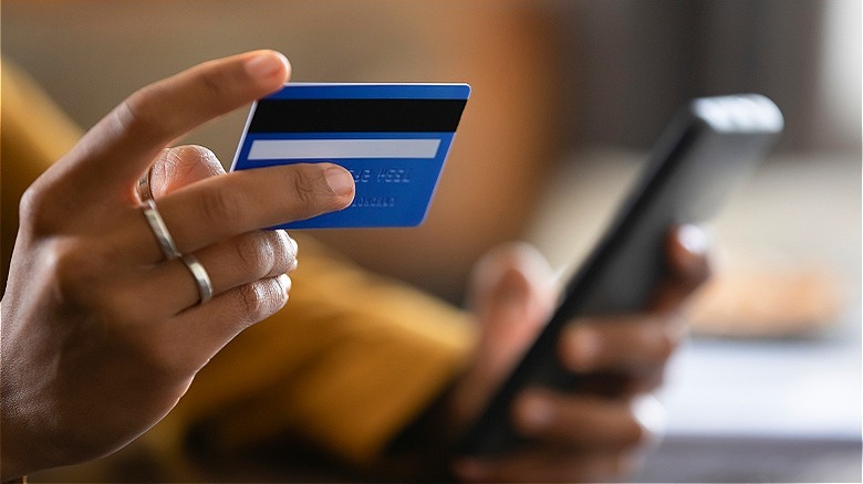 Hand holding credit card, phone