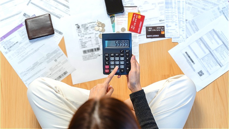 Receipts surround person making calculations