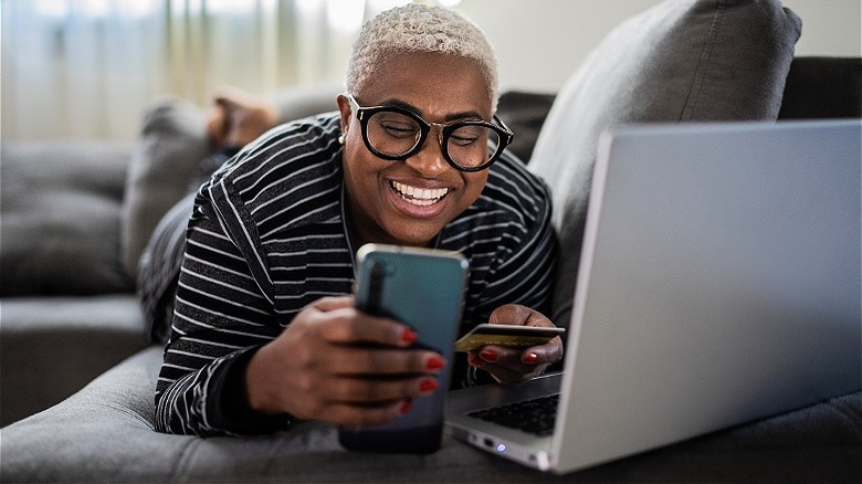 Person smiling, shopping on smartphone