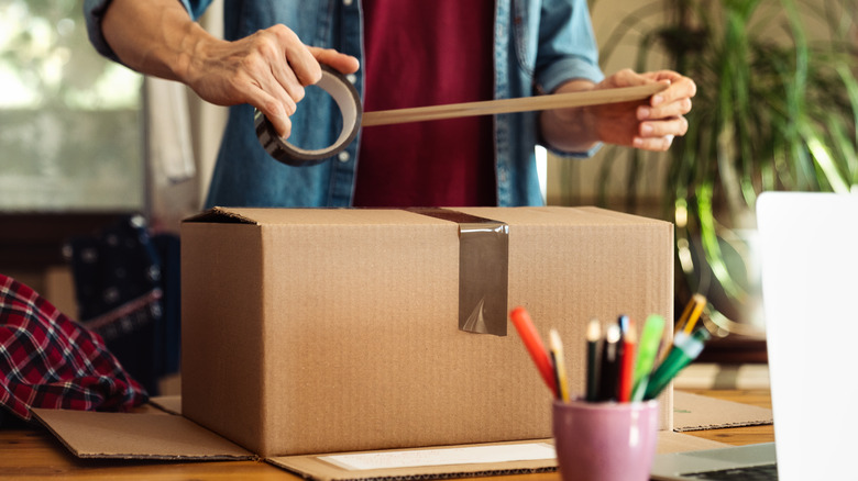 man taping box for return