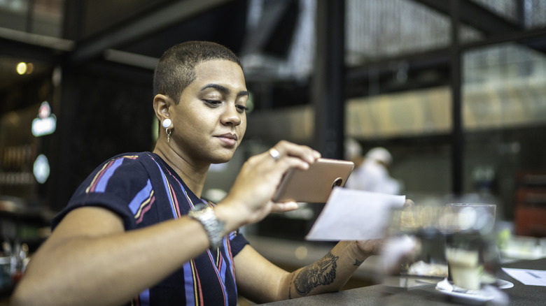 A woman taking a photo of her check