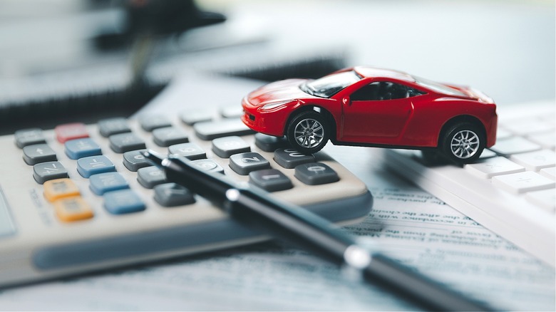 Red toy car on calculator