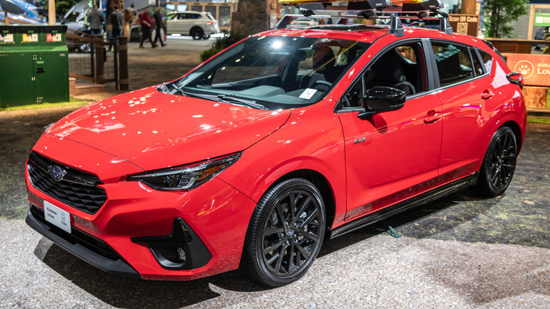 A red Subaru Impreza at an auto show