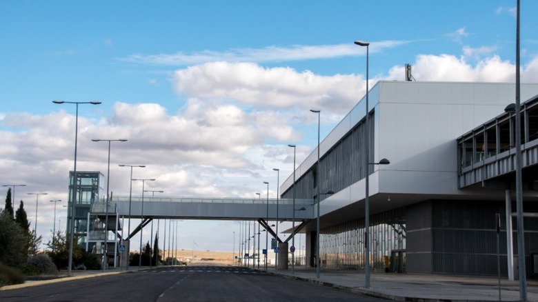 The outside of an empty terminal building and pedestrian walkway at Spain's Ciudad Real International Airport.