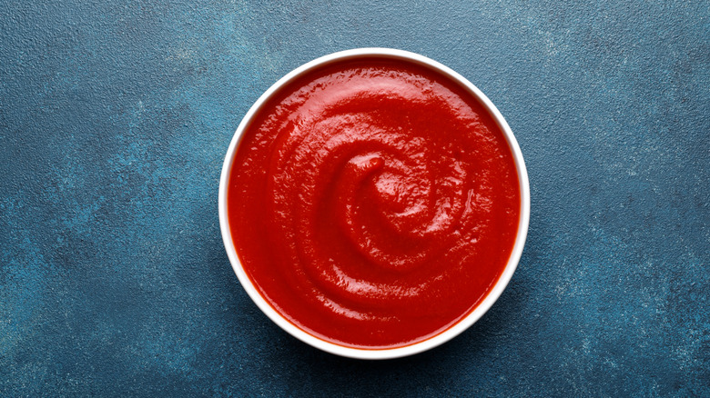 A container filled with red ketchup