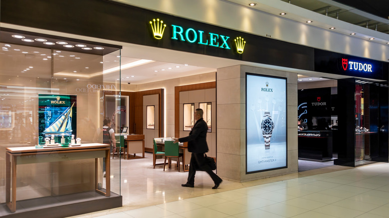 Sharply dressed man walking into a Rolex store