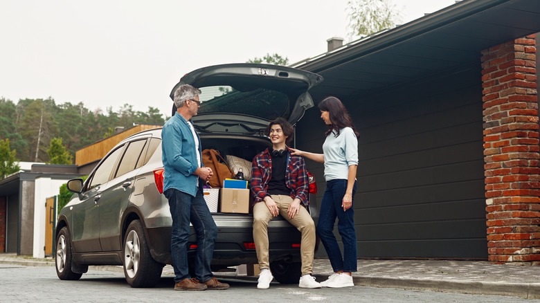 Parents sending their son off to college in front of a jam-packed car