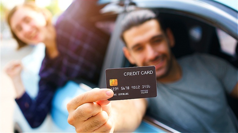 Happy couple holding credit card