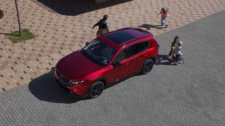 overhead view of a parked red Mazda CX-5 with a family nearby