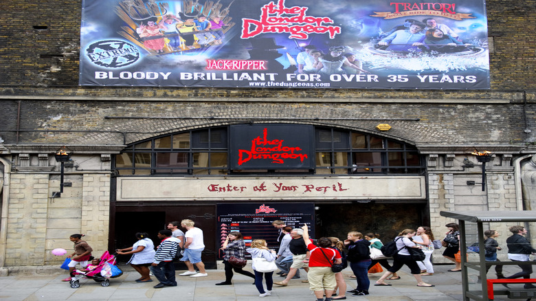 An advertisement banner hangs over The London Dungeon entrance.