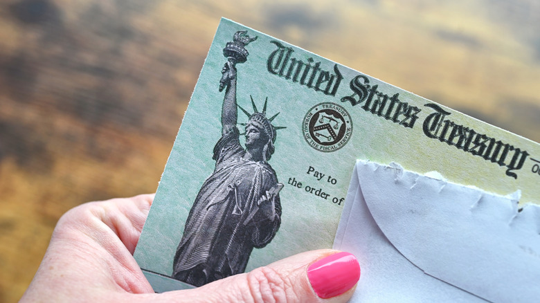 Person holding a check from the United States treasury