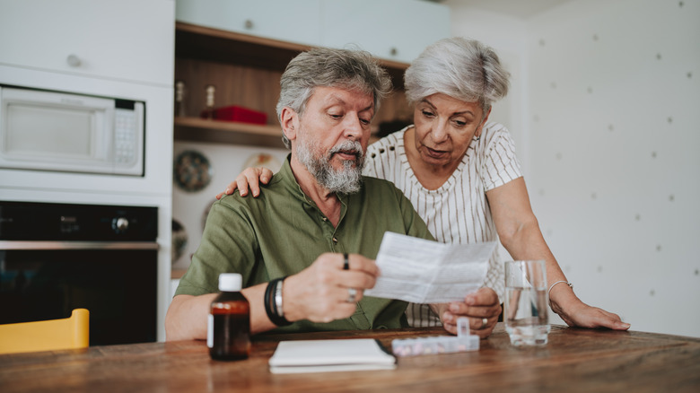 Senior couple medicating at home with medical prescription