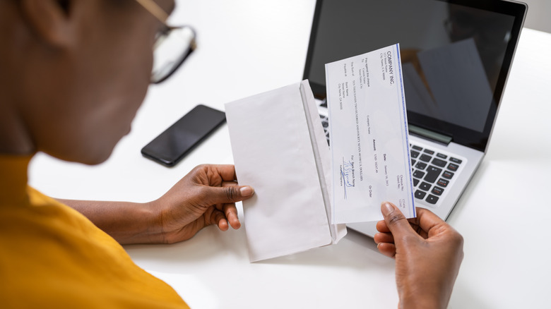 woman holding paycheck