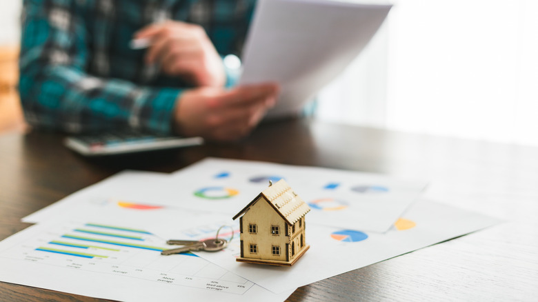 Mortgage documents and house figurine