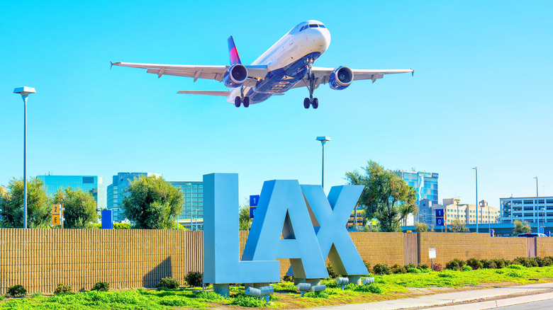 Delta Airlines plane takes off over the iconic LAX sign at Los Angeles International Airport