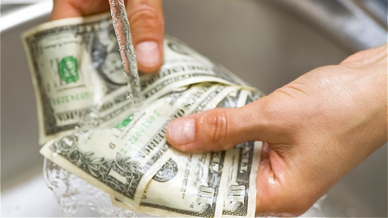 person washing currency bills