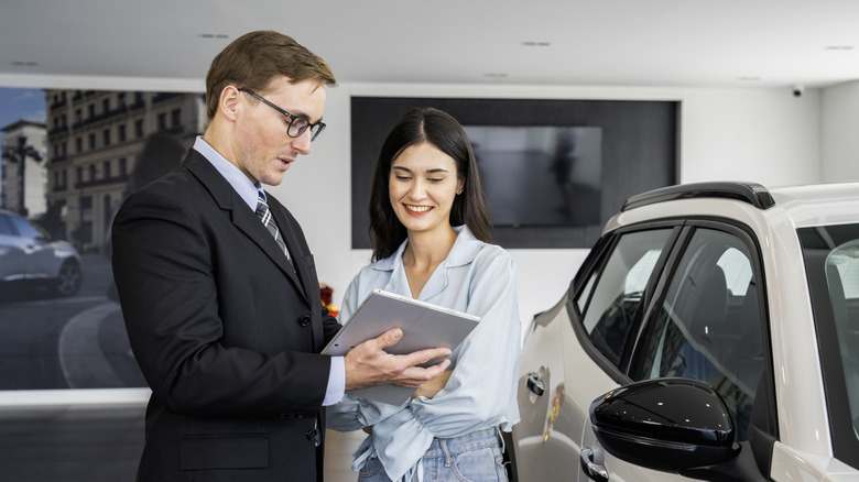 Car dealership customer talking to salesperson.